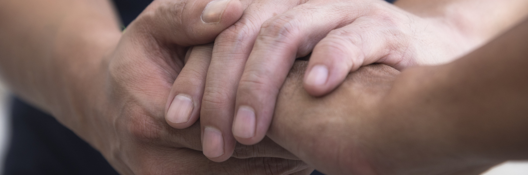 Man holding another man's hand in sympathetic, consoling gesture