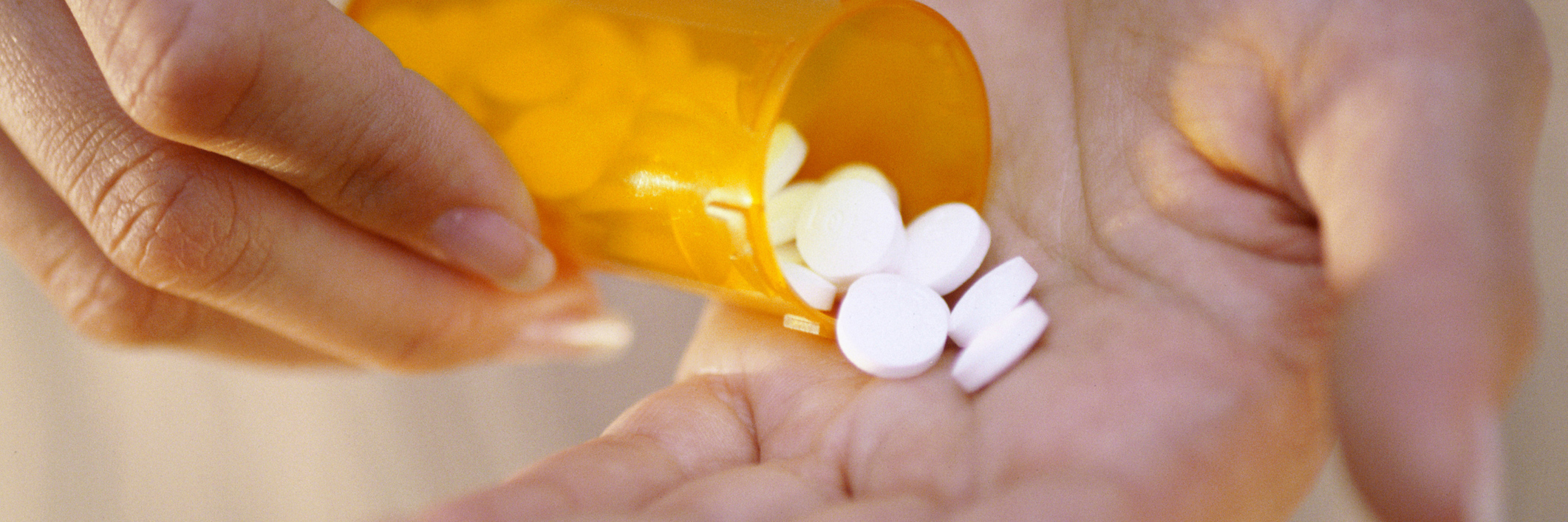 Chronic Illness: Trying Out Different Medications After Diagnosis woman pouring medication out of a bottle into her hand