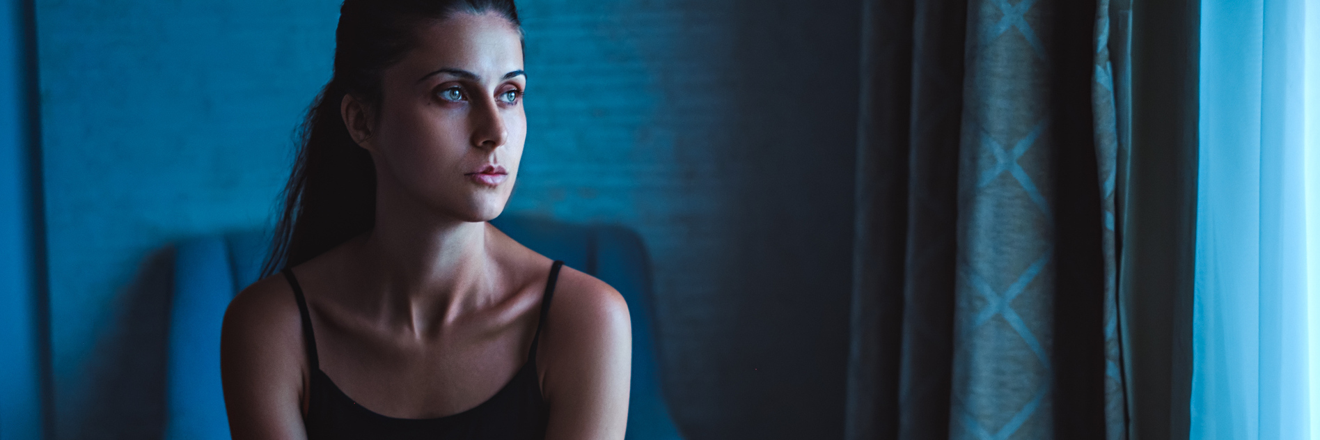 How I Learned to Accept Mental Illness and Feeling Deeply lonely woman sitting in blue room in chair by window