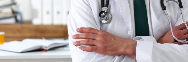 Male medicine doctor hands crossed on his chest in office