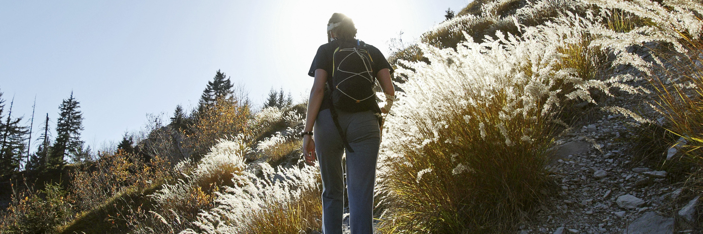 woman hiking up a steep, rocky mountain