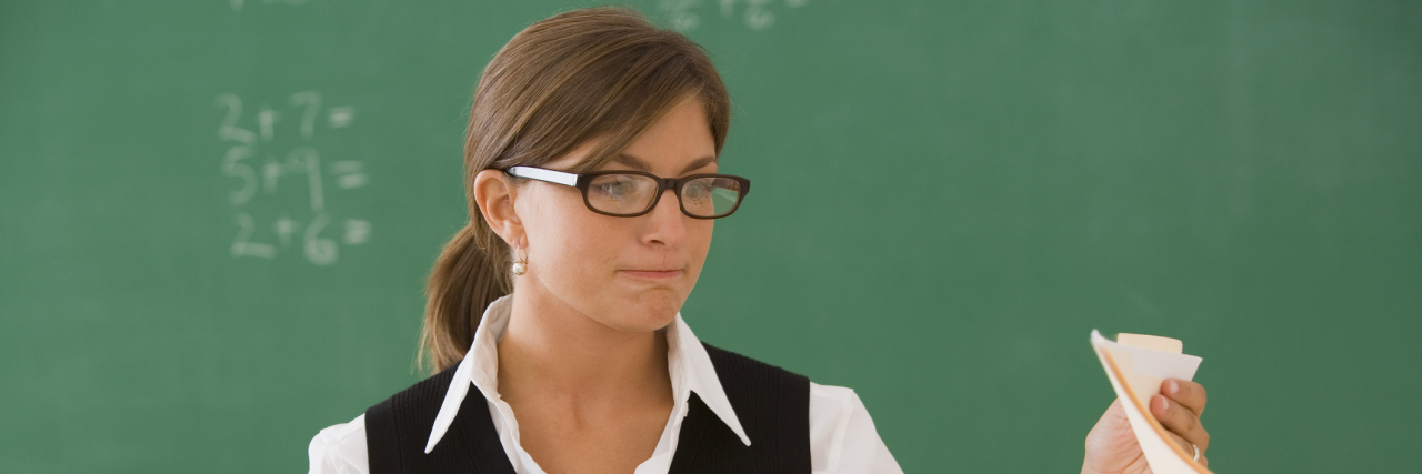 Behind My 'Blank' Face as a Teacher With Autism Teacher with papers.