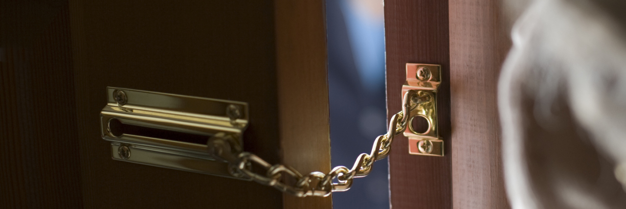 How My Depression Is Like an Unwanted Houseguest Senior woman using a security chain on front door