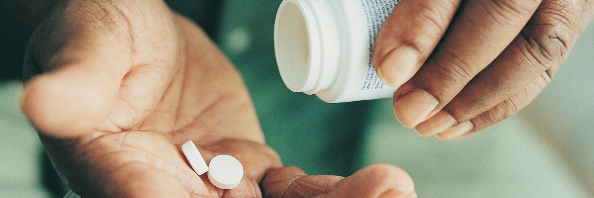 6 Wacky Side Effects of Prednisone Doctors Don't Tell You About Close-up of someone's hands, tilting a pill bottle with pills in their open palm. 6 Wacky Side Effects of Prednisone Doctors Don't Tell You About