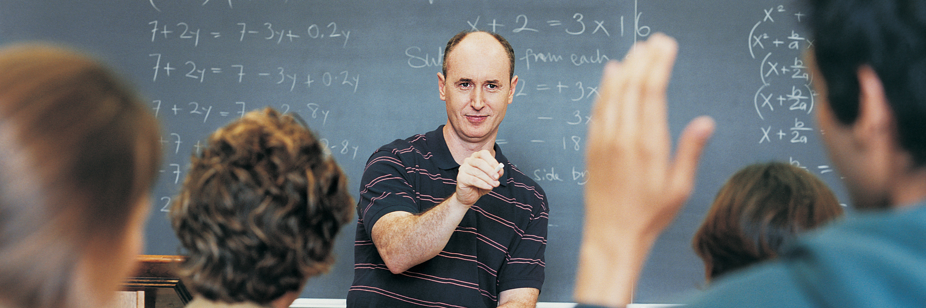 A classroom full of students being taught by a male professor.