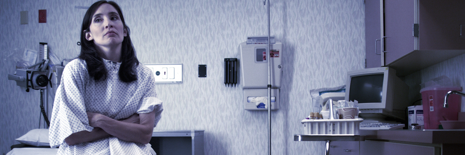 Challenges of Having a Rare Disease: My Experience Patient sitting in doctor's exam room with arms crossed