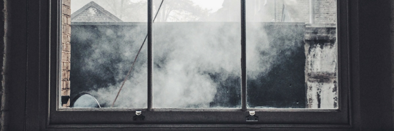 Endometriosis: Going Through Tough Times With Chronic Pain photo of window looking out on dark sky and smoke