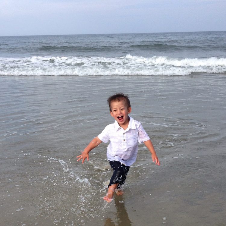 young boy running on beach