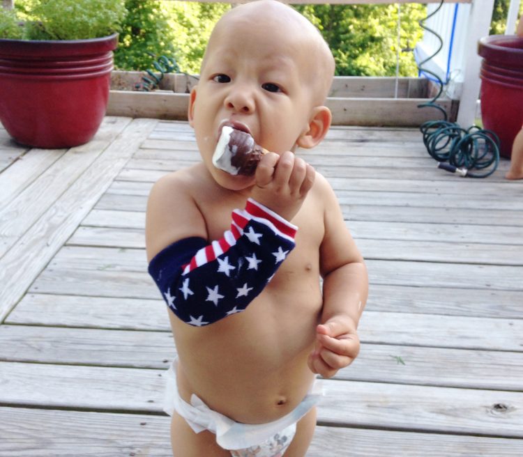 pediatric cancer child eating ice cream wearing sleevie
