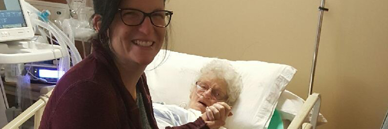 woman holding her grandmother's hand in the hospital