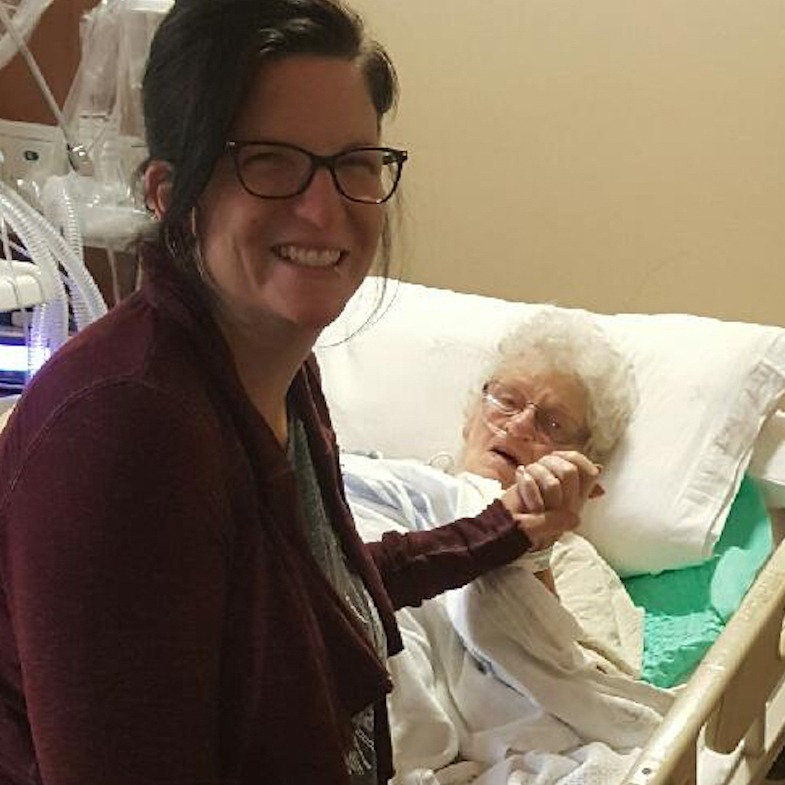 woman holding her grandmother's hand in the hospital