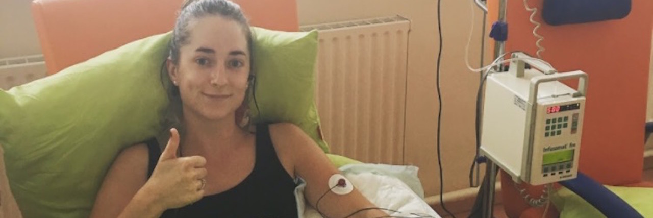 Why I Don't Want to 'Return' My Chronically Ill Body The writer sitting, hooked up to an IV.