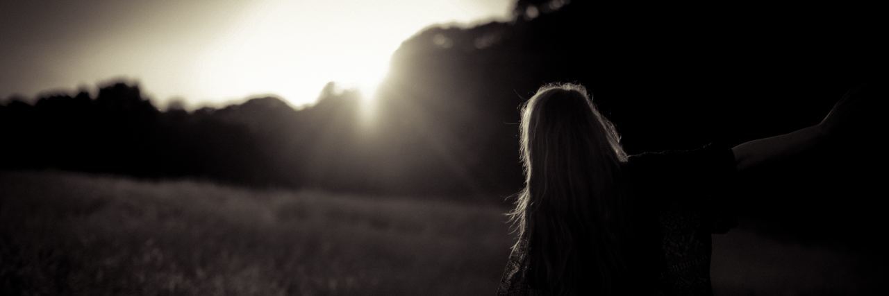 Discovering the Silver Lining in My Struggle With Depression a woman's silhouette with sun peaking over the trees