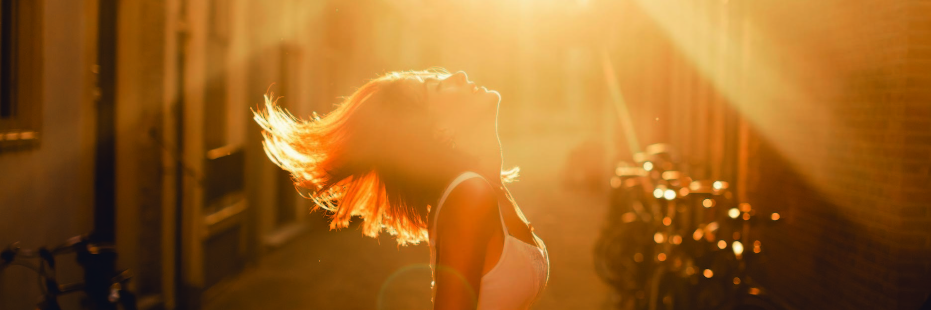 woman illuminated by sunlight in the street