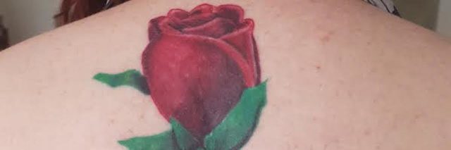tattoo of a rose on a woman's spine