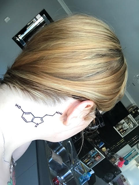 woman with serotonin tattoo on her neck