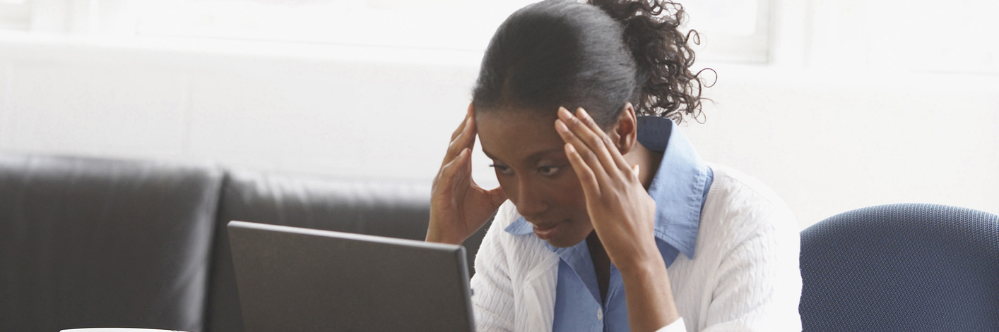 Choosing Between Job and Health With Endometriosis Businesswoman sitting in an office with her hands on her forehead