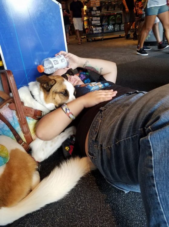woman lying on the ground with her service dog after a seizure at disneyland