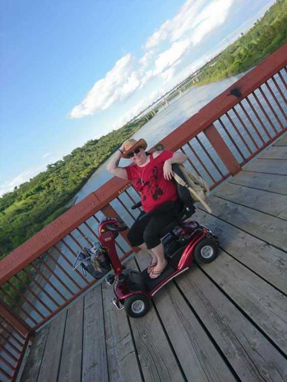 woman sitting on her mobility scooter and crossing a bridge