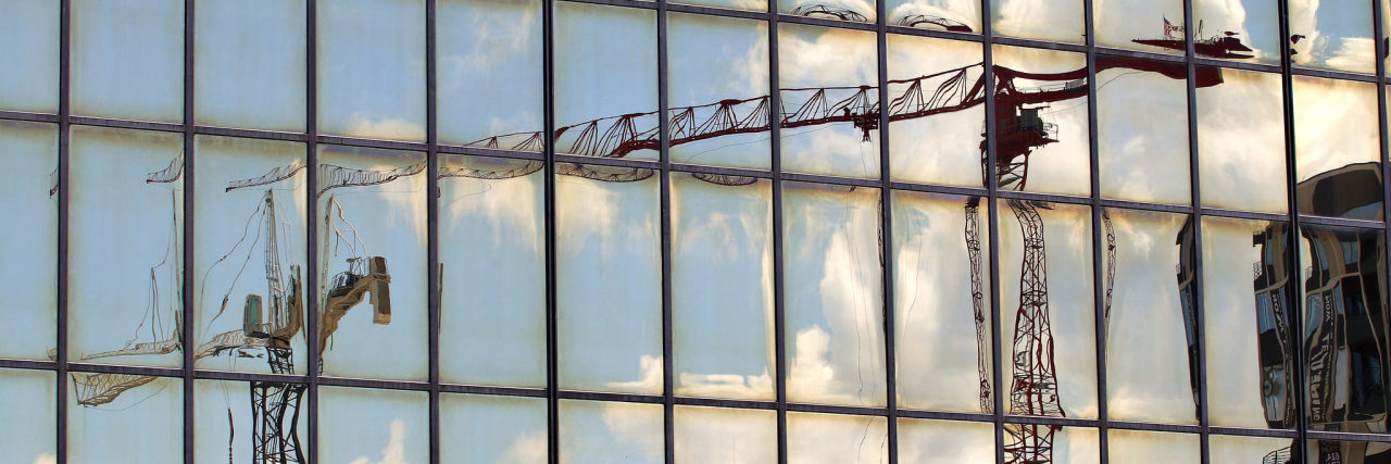 image of blurred out cranes reflected in window