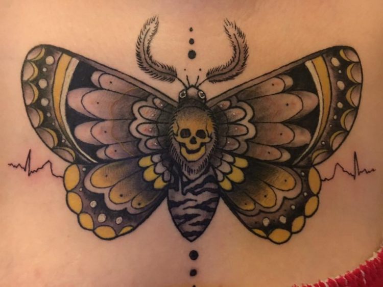 tattoo of a moth with a skull at the center