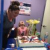 woman blowing out birthday cake candles with her daughter
