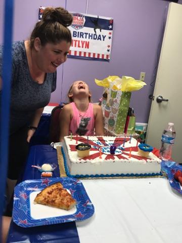 woman blowing out birthday cake candles with her daughter