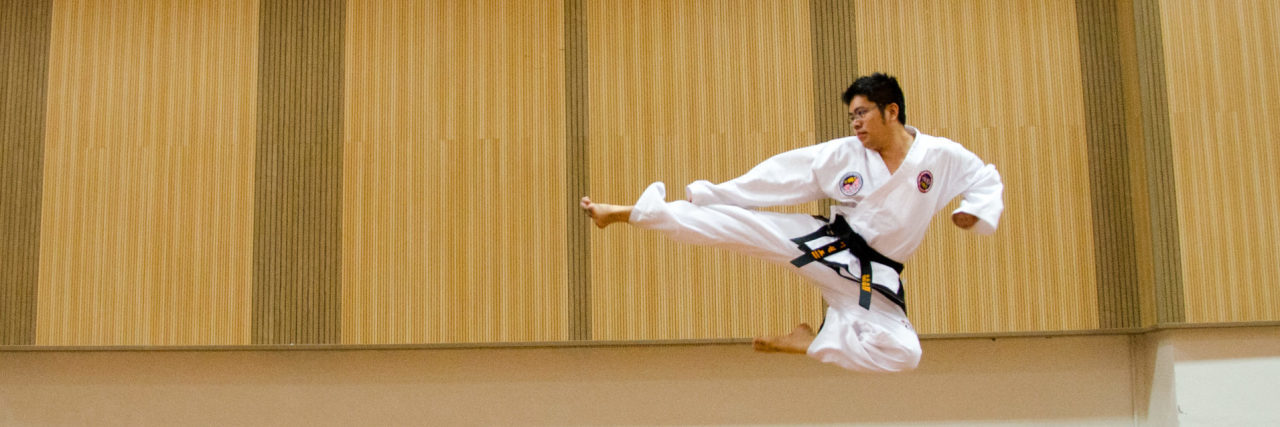 contributor image of asian man kicking through air