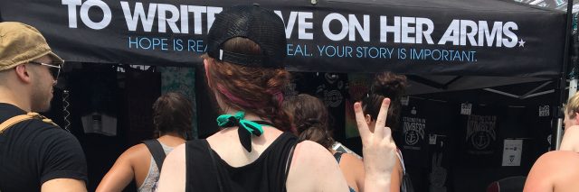 photo of girl from the back holding up peace sign