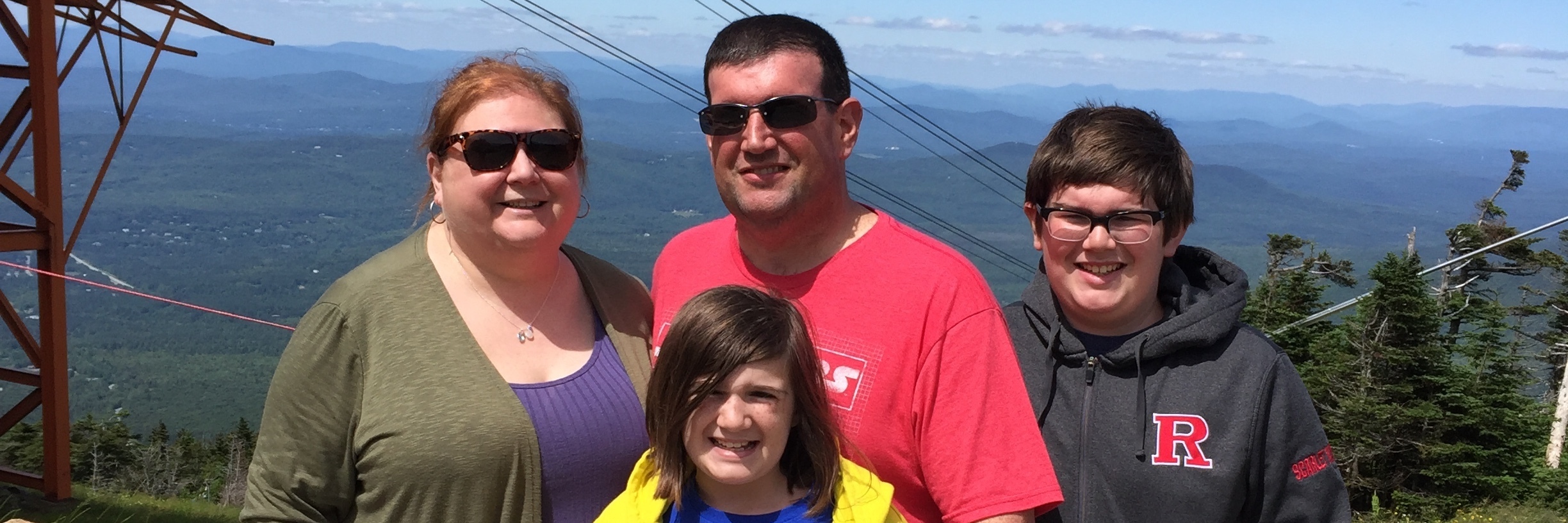 family standing together on a mountain