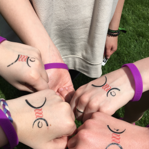 girls hands with temporary tattoos and purple bracelets