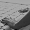 black and white photo of woman's hands gripping tiled counter