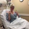 woman giving a thumbs up from her hospital bed