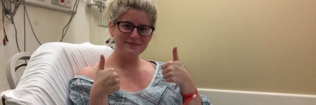 woman giving a thumbs up from her hospital bed