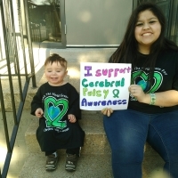 Heaven holding up a sign for cerebral palsy awareness.