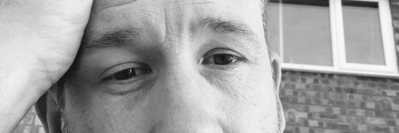 Struggling With Chronic Pain as a Man With Fibromyalgia black and white photo of a man sitting outside