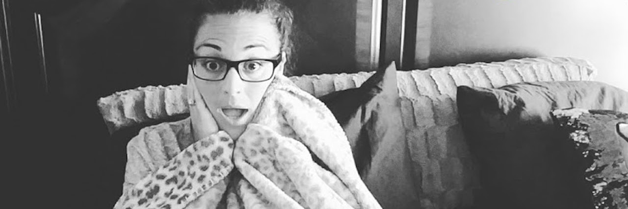 Why Sleeping Is Hard With Endometriosis woman curled up in bed with a blanket