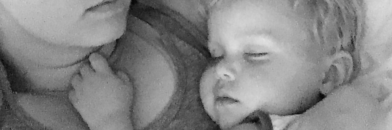 How I Realized I Had Been Struggling With Postpartum Anxiety black and white photo of woman holding baby asleep