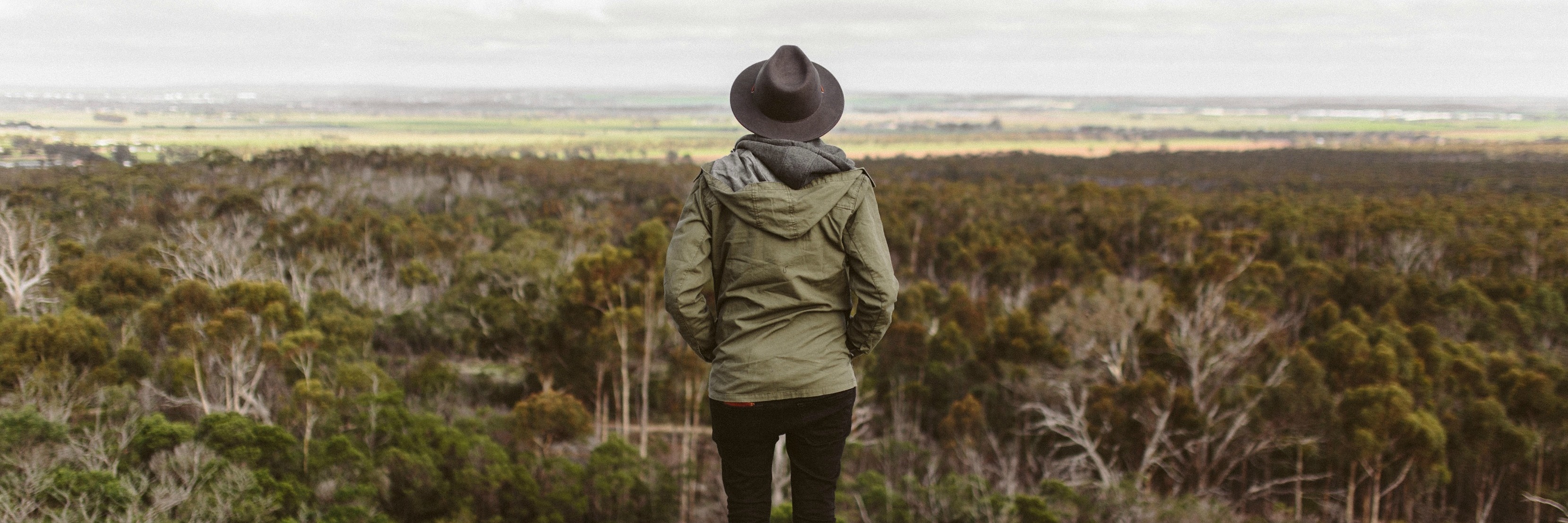 Confessions of Someone With Chronic Daily Headache, Chronic Pain woman standing on hill overlooking landscape with the text "I ask not for a lighter burden, but for bigger shoulders."