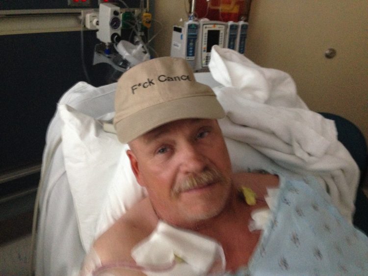 cancer patient in hospital bed with hat on