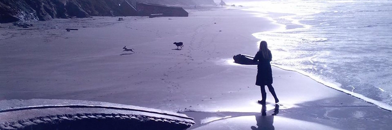 How Lyme Disease Treatment Is Like Steering a Boat Across the Ocean woman playing on the beach with her dogs