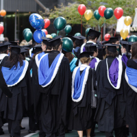 graduate students wearing their caps and gowns at a ceremony