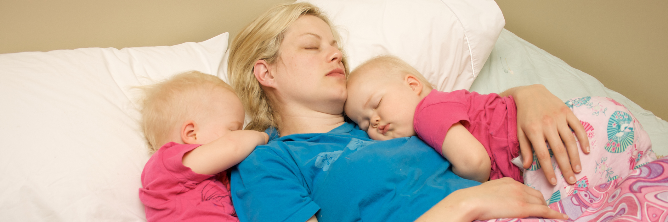 3 Ways I Balance Being Chronically Ill and Being a Parent A young mom napping with her twins.