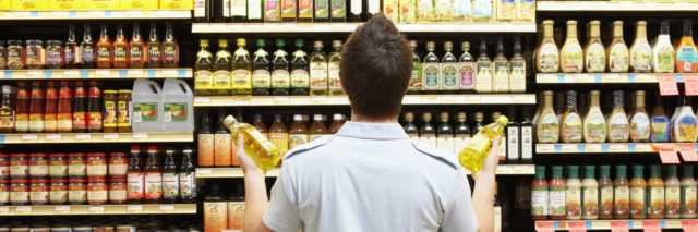 Young man looking at bottles in grocery store.