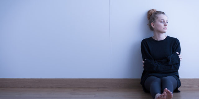 woman sitting on the floor with her arms crossed