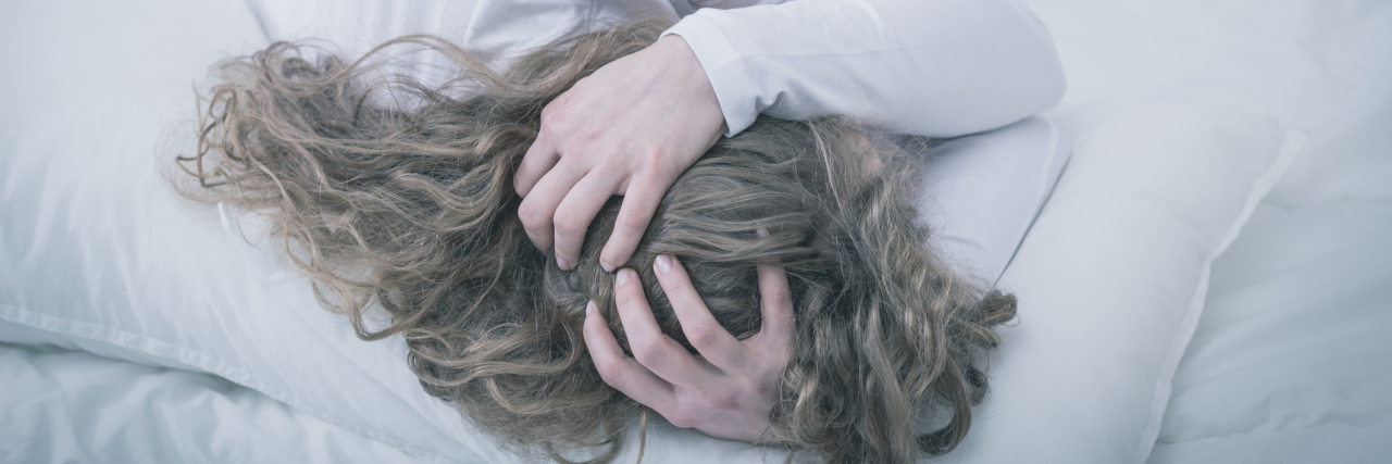 When Anxiety Feels Debilitating young woman curled up in bed depression anxiety