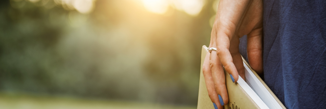 Second Round of IVF Treatment: Trying to Embrace It Woman carrying book in hand while walking on grass outdoors