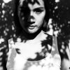 Young woman standing in tree shadows