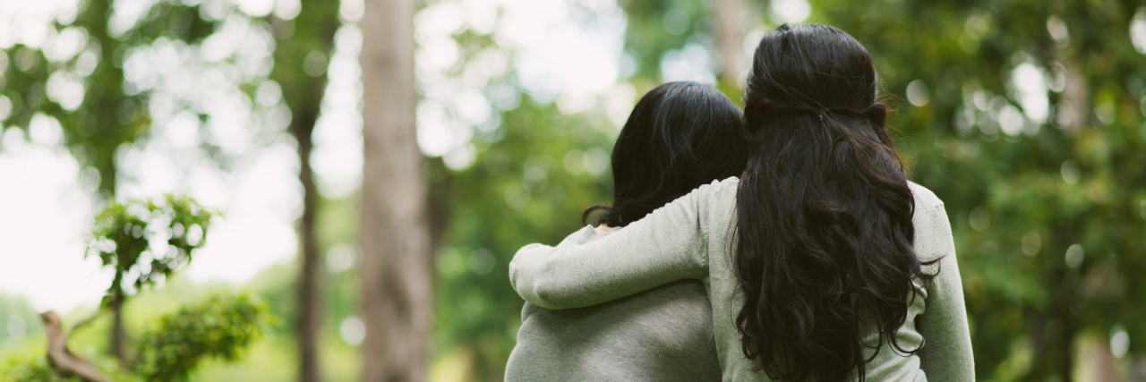 Multiple Sclerosis: Thanking Loved Ones for Their Help and Support women sitting in a park and hugging