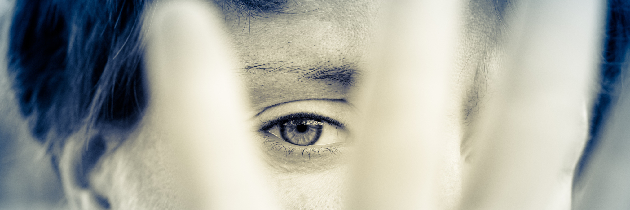The Many Faces I Hide Because of My PTSD black and white photo of woman with blue hair covering face with hand